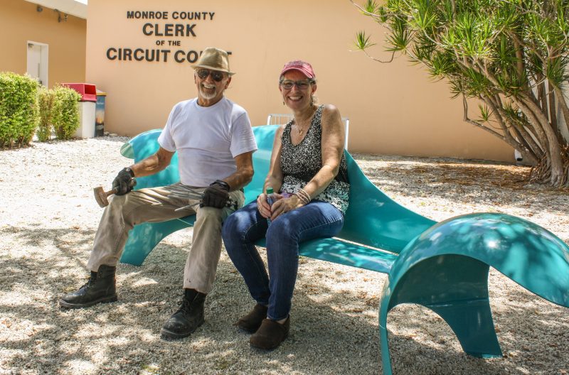 Local artist Robert D’Antonio and Elizabeth Young, Executive Director of the Florida Keys Council of the Arts, try out the new bench installed at the Monroe County Marathon Courthouse -- an Art in Public Places project. For Editorial Use Only.